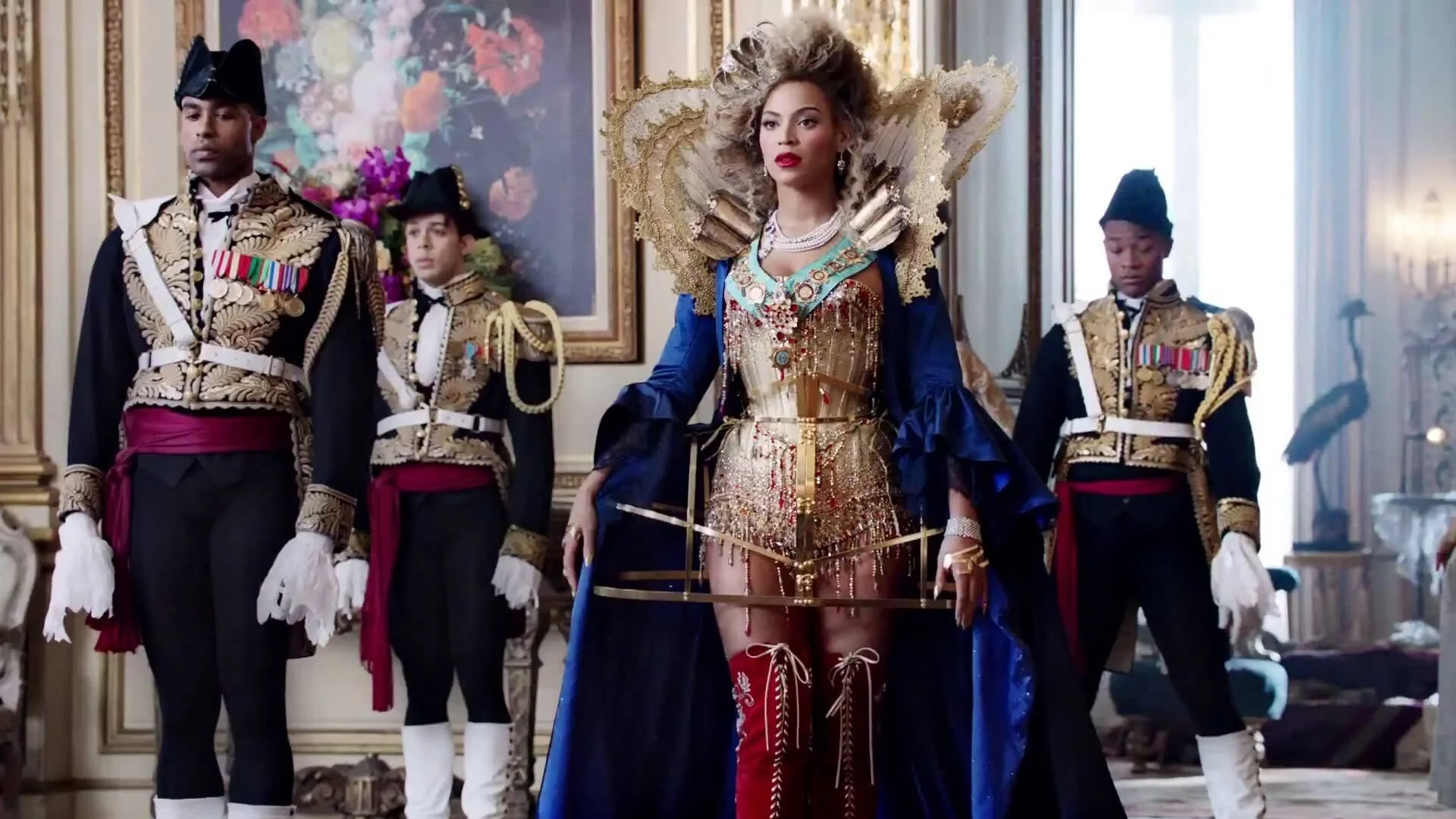 A still of a Beyonce music video with Beyonce dressed as a Queen with royal guards in the background.