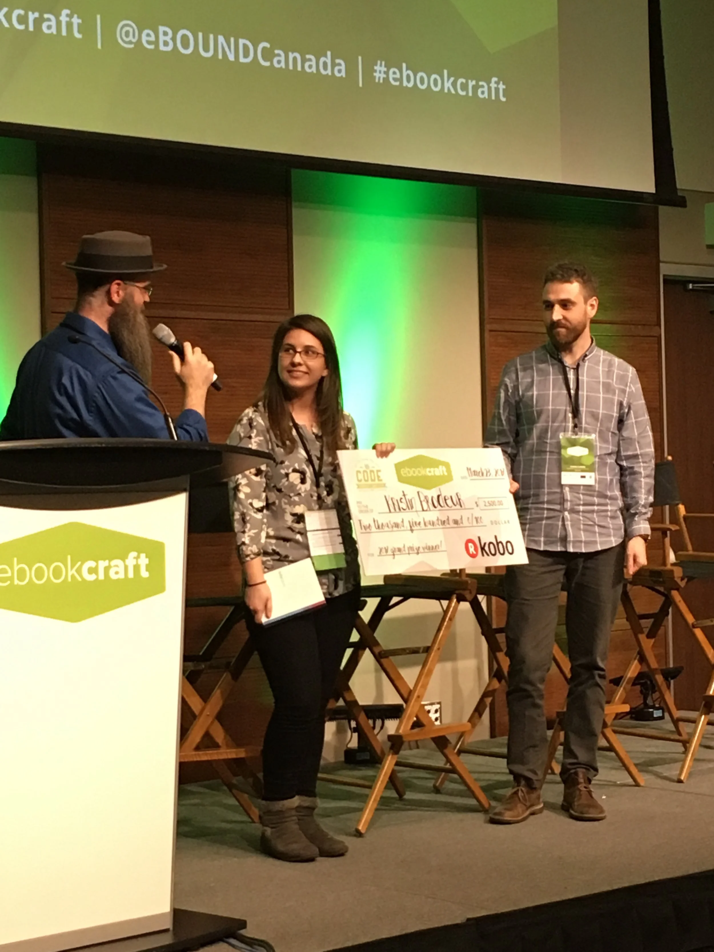   (L-R: Joshua Tallent, judge, Kristin Brodeur, winner, and Symon Flaming, Kobo representative.)  