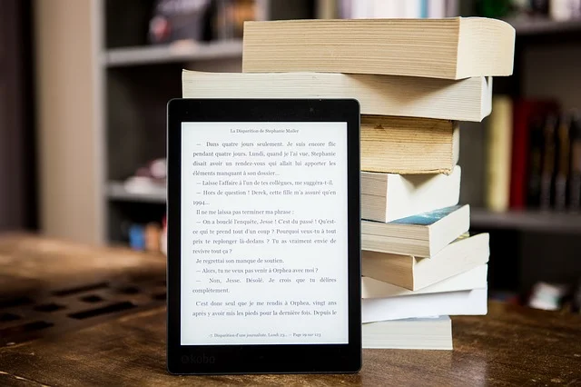  A stack of books and an iPad in front of them. 